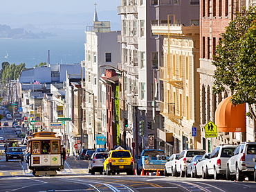 One of the famous cable cars on the Powell-Mason track, with the island of Alcatraz in the background, San Francisco, California, United States of America, North America