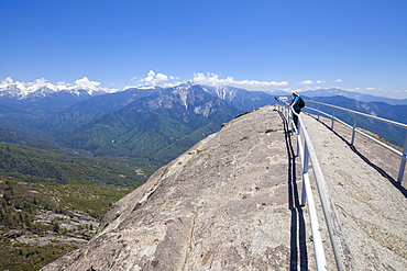 Tourist hiker, on top of Moro Rock overlooking the Sequoia foothills, looking towards Kings Canyon and the high mountains of the Sierra Nevada, Sequoia National Park, California, United States of America, North America