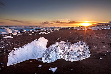 Broken ice from washed up icebergs on Jokulsarlon black beach at sunset, Jokulsarlon, southeast Iceland, Iceland, Polar Regions