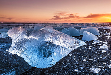 Broken ice from washed up icebergs on Jokulsarlon black beach at sunset, Jokulsarlon, southeast Iceland, Iceland, Polar Regions