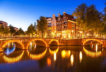 Illuminated bridges and reflections at night, Keizergracht and Leilesgracht canals, Amsterdam, North Holland, Netherlands, Europe