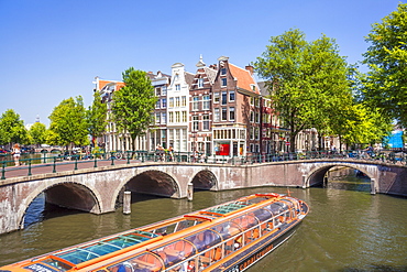 Canal tour boat and bridges at the junction of Leidsegracht Canal and Keizergracht Canal, Amsterdam, North Holland, Netherlands, Europe