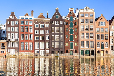 Dutch gables on a row of typical Amsterdam houses with reflections, Damrak Canal, Amsterdam, North Holland, Netherlands, Europe