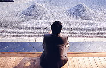 Figure sat comtemplating Zen garden, Kyoto, Japan