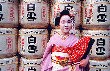 Portrait of a Maiko (a geisha's apprentice) in front of temple lanterns, Kyoto, Japan