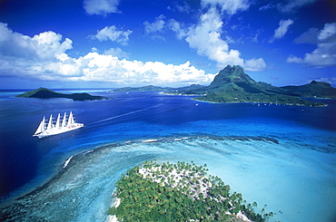 Aerial view over tropical islands including large yacht and lagoon