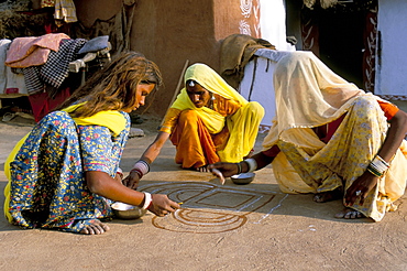 Women painting a mandana on the ground, village near Jodhpur, Rajasthan state, India, Asia