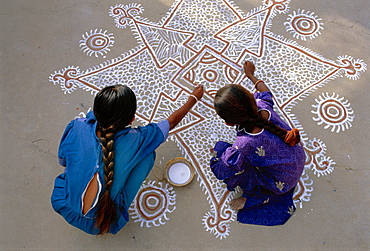 Women painting a Mandana on the ground, Village near Jodhpur, Rajasthan, India 