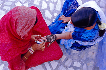 Woman's hand being decorated with henna design, Rajasthan, India