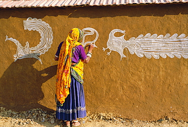 Woman decorating her house with traditional local designs, Tonk region, Rajasthan, India, Asia