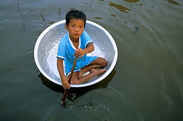 Small boy in circular metal boat, Lake Tonle Sap, Chong Kneas village, Siem Reap, Cambodia, Indochina, Southeast Asia, Asia