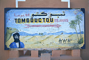 Painted road sign pointing in the direction of Tombouctou (Timbuktu), in the town of Zagora, Vallee du Draa (Draa Valley), Anti Atlas, Morocco, North Africa, Africa