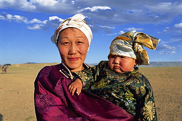 Head and shoulders portrait of a smiling nomad woman and child in traditional clothing, looking at the camera, at Naadam Festival, Altai, Gov-altai, Mongolia, Central Asia, Asia