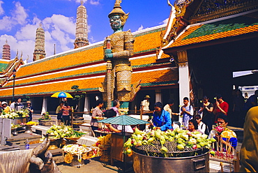 People worshipping and offering flowers in the Wat Phra Kaew complex, Grand Palace, Bangkok, Thailand