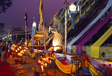 People worshipping during Buddhist festival at the foot of temple chedi, Wat Chedi Luang, Chiang Mai, Thailand, Southeast Asia, Asia