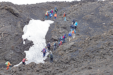 Group of hikers walking up to Mount Etna summit, Etna, Sicily, Italy