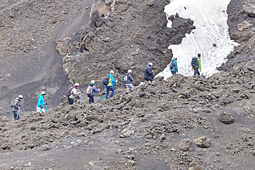 Group of hikers walking up to Mount Etna summit, Etna, Sicily, Italy