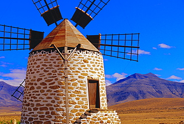 Old Windmill with volcanoes in background near Tefia, Fuerteventura, Canary Islands, Spain