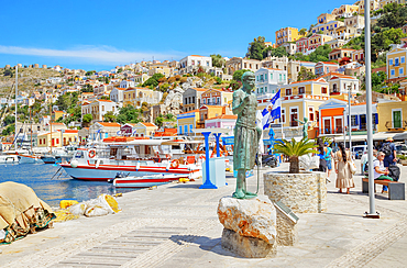 Monument to the legendary Greek sponge diver Stathis Hatzis on Gialos harbour waterfront, Symi Island, Dodecanese Islands, Greece