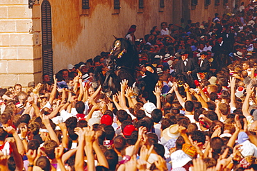 Rider on a rearing horse among the crowds during Sant Joans festival, Ciutadella, Minorca, Spain