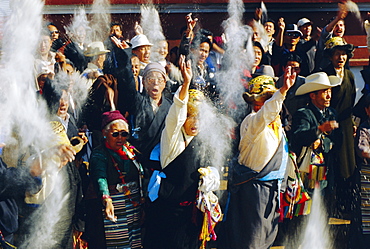 Buddhist people throwing flour into the air, symbolising the Buddha's wisdom, during the Losar (Tibetan New Year), Bodhnath, Katmandu, Nepal