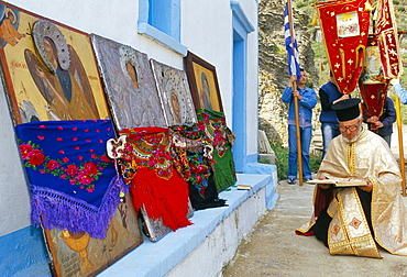 Greek Orthodox priest praying during Lambri Triti festival, Olymbos (Olimbos), Karpathos, Dodecanese islands, Greece, Mediterranean, Europe