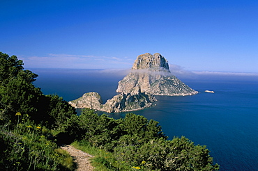 The rocky islet of Es Vedra surrounded by mist, with pine trees in foreground, near Sant Antoni, Ibiza, Balearic Islands, Spain, Mediterranean, Europe