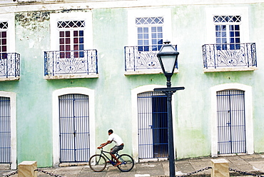 Man riding bicycle in front of old colonial house, Sao Luis, Maranhao, Brazil, South America