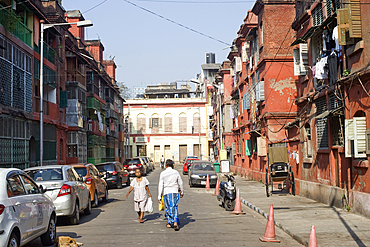 Two pedestrians walking along a street in Bow Barracks quarter of north central Kolkata (Calcutta), West Bengal, India, Asia