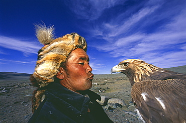 Kazakh nomad with Golden eagle {Aquila chrysaetos} trained for hunting, Tsengel Khairkhan mountains, W Mongolia