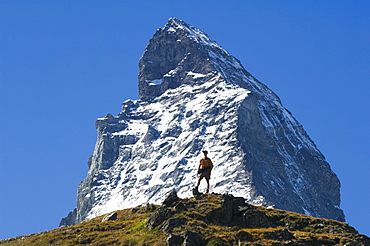 Hiker below the peak of the Matterhorn, 4477m, Zermatt Alpine Resort, Valais, Switzerland, Europe