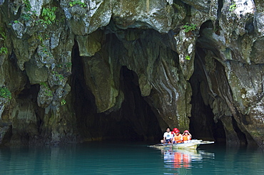 Tourists in paddle boat at entrance to Riverine Cave. longest navigable river traversed tunnel in the world, Subterranean River National Park, Sabang Town, Palawan, Philippines, Southeast Asia, Asia