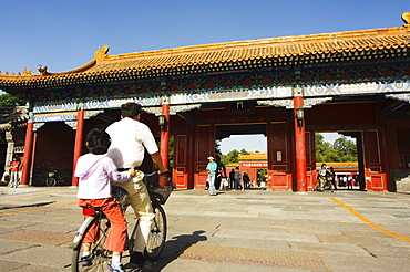 A cyclist at a gate to Zijin Cheng The Forbidden City Palace Museum, UNESCO World Heritage Site, Beijing, China, Asia