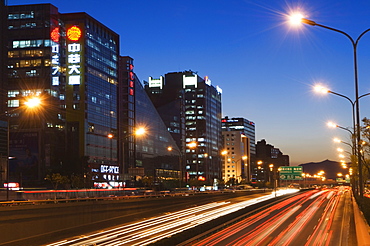 Car light trails and modern architecture on a city ring road, Beijing, China, Asia