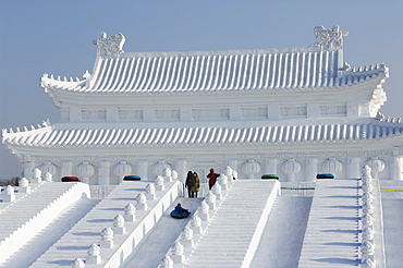 A boy slides down a giant replica sculpture of Beijing's Forbidden City at the Snow and Ice Sculpture Festival on Sun Island Park, Harbin, Heilongjiang Province, Northeast China, China, Asia