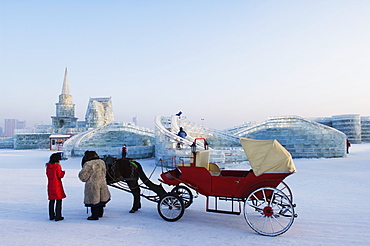 A horse and carriage ride and snow and ice sculptures at the Ice Lantern Festival, Harbin, Heilongjiang Province, Northeast China, China, Asia