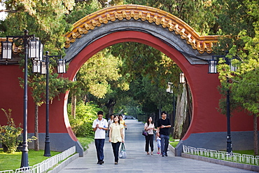 Visitors walking through an arched gate at Zhongshan Park, Beijing, China, Asia