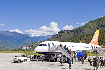 Passenger plane at Paro International Airport, Paro Rinpung Dzong in the distance, Paro, Bhutan, Himalayas, Asia