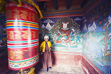 A woman spinning a prayer wheel, Chimi Lhakhang dating from 1499, Temple of the Divine Madman Lama Drukpa Kunley, Punakha, Bhutan, Asia