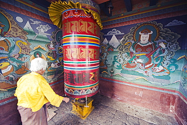 A woman spinning a prayer wheel, Chimi Lhakhang dating from 1499, Temple of the Divine Madman Lama Drukpa Kunley, Punakha, Bhutan