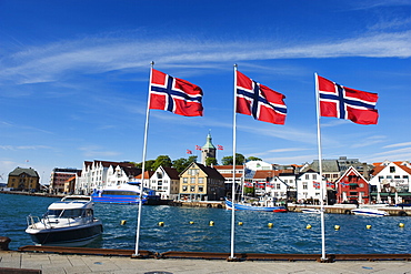 Norwegian flags and historic harbour warehouses, Stavanger, Norway, Scandinavia, Europe