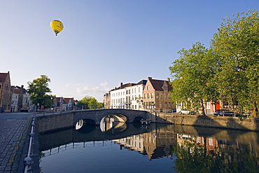 Hot air balloon floating over rooftops, houses reflected in a canal, old town, UNESCO World Heritage Site, Bruges, Flanders, Belgium, Europe