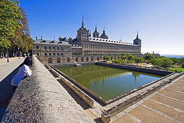 Girl looking at San Lorenzo de El Escorial mausoleum and palace of the Spanish monarchs, El Escorial, UNESCO World Heritage Site, Madrid, Spain, Europe