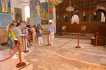 Tourists and guide looking at the mosaic map dating from 560 AD, St. George's Church, Madaba, Jordan, Middle East