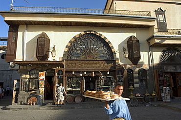 Man with bread walking past souvenir shop, Damascus, Syria, Middle East