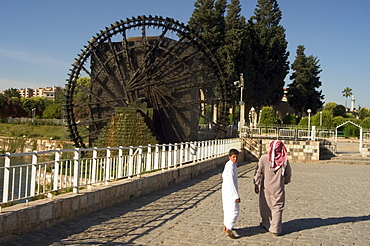 Local people near water wheel on the Orontes River, Hama, Syria, Middle East