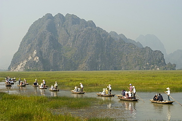 Punting boats on delta river, limestone mountain scenery, Van Long, Ninh Binh, south of Hanoi, North Vietnam, Southeast Asia, Asia