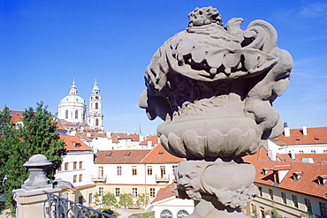 Baroque statue at Vrtbovska Garden with Baroque St. Nicholas Church in the background, Mala Strana, Prague, Czech Republic, Europe