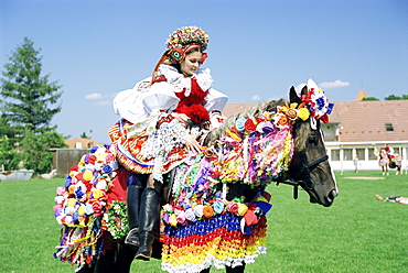 Young woman wearing folk dress on horseback, Ride of the Kings Festival, village of Vlcnov, Moravian Slovacko, Vlcnov, Zlinsko, Czech Republic, Europe