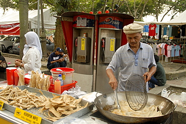 Food vendor frying food outside Central Market, Kuala Lumpur, Malaysia, Southeast Asia, Asia